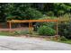 Wooden pergola covers garden beds with stone trim, offering shade along a driveway at 130 Robin Rd, Marietta, GA 30067
