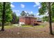 Brick home on a large lot features a spacious backyard, mature trees, a patio, and lush landscaping at 130 Robin Rd, Marietta, GA 30067