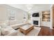 Bright living room featuring a fireplace, built-in shelves, hardwood floors, and large windows at 3694 Lambert Ne Ln, Atlanta, GA 30319