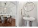 Stylish powder room with a pedestal sink and decorative mirror, adjacent to the dining room at 3694 Lambert Ne Ln, Atlanta, GA 30319