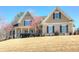 Inviting two-story home with a covered porch, manicured lawn, and detailed architectural features under a clear blue sky at 103 Old Avery Dr, Canton, GA 30115