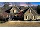 Charming two-story home featuring a welcoming front porch, gable roof, and manicured landscaping, set against a beautiful sky at 103 Old Avery Dr, Canton, GA 30115
