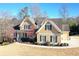 Inviting two-story home with a covered porch, manicured lawn, and detailed architectural features under a clear blue sky at 103 Old Avery Dr, Canton, GA 30115
