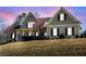 Charming two-story home featuring a welcoming front porch, gable roof, and manicured landscaping, set against a vibrant twilight sky at 103 Old Avery Dr, Canton, GA 30115