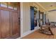 Inviting porch with rocking chairs, a wooden door, and black shutters, creating a welcoming outdoor living space at 103 Old Avery Dr, Canton, GA 30115