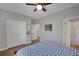 Bedroom featuring a blue-and-white quilt, hardwood floors, and ample closet space at 541 Glen Abbey Se Cir, Mableton, GA 30126