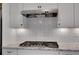 Gas range with a designer tile backsplash and a stainless steel vent hood at 541 Glen Abbey Se Cir, Mableton, GA 30126