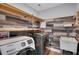 Convenient laundry room with modern washer and dryer, utility sink, and stylish wood-look accent wall at 541 Glen Abbey Se Cir, Mableton, GA 30126