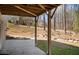 Covered patio with wooden support beams and concrete flooring overlooks the backyard and surrounding trees at 541 Glen Abbey Se Cir, Mableton, GA 30126