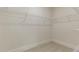 Neutral walk-in closet features white wire shelving, neutral carpeting, and base molding at 64 Lakeview Pt, Dallas, GA 30157