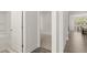 Bright hallway view leads to a bathroom on the left and an open-concept kitchen and dining area ahead at 64 Lakeview Pt, Dallas, GA 30157