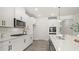 Bright, modern kitchen with white cabinets, stainless steel appliances, ample counter space, and sleek hardwood floors at 64 Lakeview Pt, Dallas, GA 30157