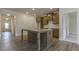 Open kitchen boasts an island, stainless steel sink, granite counters, wood cabinets, and hardwood floors at 64 Lakeview Pt, Dallas, GA 30157