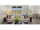 Bright living room featuring a plush sofa, decorative pillows, and a view of the outdoor landscape at 64 Lakeview Pt, Dallas, GA 30157