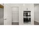 Modern kitchen features a spacious walk-in pantry with white wire shelving and a built-in double oven at 64 Lakeview Pt, Dallas, GA 30157