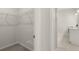 Walk-in closet with wire shelving next to bright white bathroom with tile floor and vanity at 64 Lakeview Pt, Dallas, GA 30157