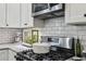 Close-up of a well-equipped kitchen featuring subway tile backsplash and modern stainless steel appliances at 1211 Mortimer Se Pl, Atlanta, GA 30317