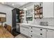 Bright kitchen with farmhouse sink, open shelving, and stylish cabinets offers ample storage and charm at 1211 Mortimer Se Pl, Atlanta, GA 30317