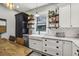 Kitchen featuring white cabinets, a farmhouse sink, and open shelving at 1211 Mortimer Se Pl, Atlanta, GA 30317