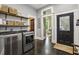 Laundry room with modern washer and dryer, storage shelves and black door at 1211 Mortimer Se Pl, Atlanta, GA 30317