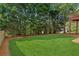 Well-manicured backyard featuring a lush lawn and mature trees at 1316 Wind Chime Ct, Lawrenceville, GA 30045