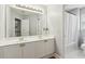 Bathroom featuring double sinks, framed mirror, and shower/tub combination with white tile at 1316 Wind Chime Ct, Lawrenceville, GA 30045