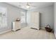 Cozy bedroom with neutral carpet, ceiling fan, and white armoire and dresser for ample storage at 1316 Wind Chime Ct, Lawrenceville, GA 30045