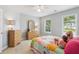 Cozy bedroom with a colorful quilt, two windows, and light wood dressers at 1316 Wind Chime Ct, Lawrenceville, GA 30045