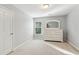 Bright bedroom with neutral walls, plush carpet, window, and white dresser for a clean and calming space at 1316 Wind Chime Ct, Lawrenceville, GA 30045