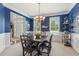 Dining room with blue walls, white trim, a wooden table, and a chandelier at 1316 Wind Chime Ct, Lawrenceville, GA 30045