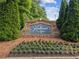 Stone entrance sign for Knollwood Lakes with manicured flower beds in a landscaped median under mature trees at 1316 Wind Chime Ct, Lawrenceville, GA 30045