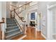 Foyer with hardwood floors, staircase with white railings, and a view into the living room at 1316 Wind Chime Ct, Lawrenceville, GA 30045