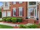 Close-up view of the home's front entrance with brickwork, manicured bushes, and a two-car garage at 1316 Wind Chime Ct, Lawrenceville, GA 30045