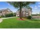 Expansive green front yard featuring a mature tree, long driveway, and neighboring homes at 1316 Wind Chime Ct, Lawrenceville, GA 30045