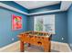 Game room features natural light, ceiling detail, and Foosball table for endless fun and entertainment at 1316 Wind Chime Ct, Lawrenceville, GA 30045