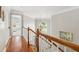 Bright hallway with hardwood floors, white railings, and a decorative chandelier at 1316 Wind Chime Ct, Lawrenceville, GA 30045