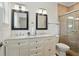 Well-lit bathroom featuring double sinks, granite counters, a tile shower, and tasteful neutral decor at 2610 Cheney St, East Point, GA 30344