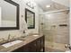 Bathroom featuring a double sink vanity, marble countertop, and a walk-in shower with glass doors at 2610 Cheney St, East Point, GA 30344