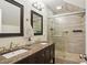 Modern bathroom featuring a dual sink vanity, a tiled glass shower, and decorative mirrors at 2610 Cheney St, East Point, GA 30344