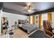 Stylish bedroom with a black ceiling, ceiling fan, and mustard-colored curtains provides a comfortable retreat at 2800 Tuscany Park Dr, Lawrenceville, GA 30043