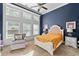 Bright bedroom featuring a large window, sitting chair, and a luxurious bed with white frame and mustard-colored coverlet at 2800 Tuscany Park Dr, Lawrenceville, GA 30043
