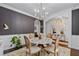 Chic dining room with wainscoting, a modern chandelier, and a marble table, perfect for gatherings at 2800 Tuscany Park Dr, Lawrenceville, GA 30043
