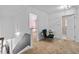 Hallway with access to a laundry room and bedroom. Features a chair and view of the staircase at 2800 Tuscany Park Dr, Lawrenceville, GA 30043