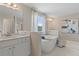 Bright bathroom with a soaking tub next to a window, with dual sinks and a mirror at 408 Hatcher Ct, Hampton, GA 30228