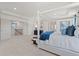 Open, bright main bedroom with white canopy bed, blue accents and a view of the staircase at 408 Hatcher Ct, Hampton, GA 30228