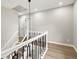 Second floor hallway with black metal railing, white trim, and modern pendant lighting at 5427 Fieldgreen Dr, Stone Mountain, GA 30088