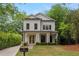 Charming two-story home with white siding, black trim, manicured landscaping, and a welcoming front porch at 357 Mell Ave, Atlanta, GA 30307