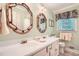 A bathroom featuring a double sink vanity with decorative mirrors, a window, and neutral-toned walls at 3592 Midvale Cv, Tucker, GA 30084