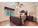 A bedroom featuring a wooden bed, ceiling fan with lights, and a window providing natural light at 3592 Midvale Cv, Tucker, GA 30084