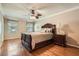 Bedroom features hardwood floors, ceiling fan, bedside tables, and bright windows at 3592 Midvale Cv, Tucker, GA 30084